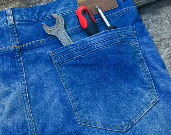 Mechanics Tool Set. Screwdriver and wrench in a pocket of blue jeans. Tools for general repair. Building