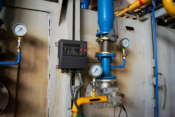 Gauges in the boiler room near the heating pipes with insulation coating. Electric power meter measuring power usage. Watt hour electric meter measurement tool. oil and gas pipeline — Stock Image Gauges Boiler Room Heating Pipes Insulation Coating Electric Power Meter Stock Picture