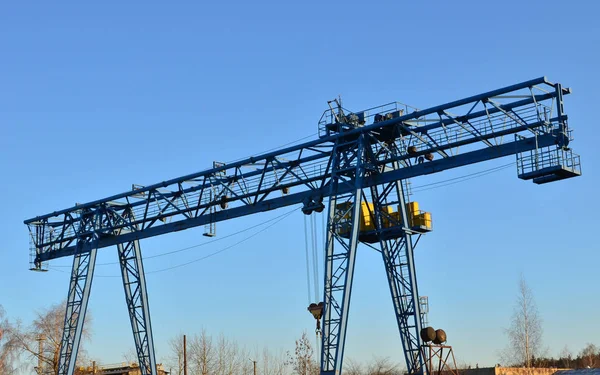 Gantry crane with hook for lifting and moving heavy cruz. Construction site. Industrial plant