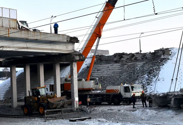 Lifting truck crane, dismantling a large reinforced concrete slab, construction of an automobile bridge at a construction site.