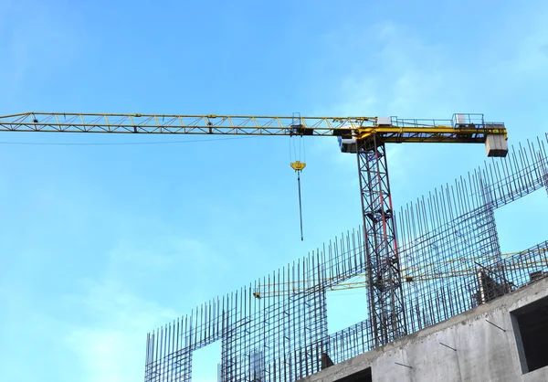 Construction works in preparation for the binding of reinforcement bars and concrete works, against the background of the construction crane and the facade of the building - Image