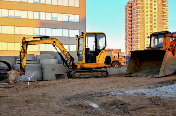 Mini excavator on a construction site,  on a street reconstruction