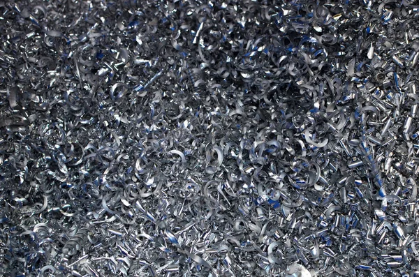 Steel scrap materials recycling. Abstract, background and texture of metal shavings. Aluminum chip waste after machining metal parts on a cnc lathe