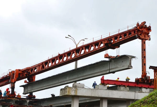 Repair of the automobile bridge over the railway. Mounting crane removes reinforced concrete beams. Bridge girder erection machine. Bridge construction, Minsk, Belarus