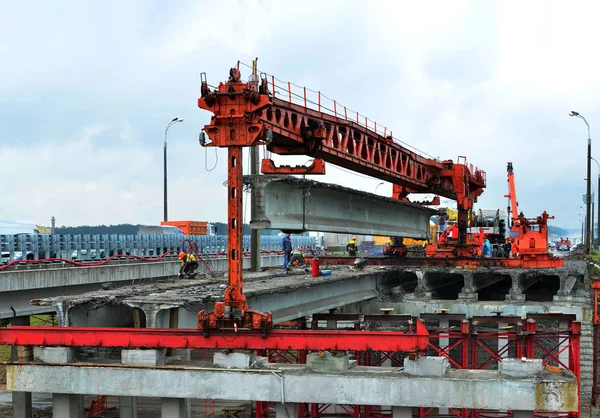 Repair of the automobile bridge over the railway. Mounting crane removes reinforced concrete beams. Bridge girder erection machine. Bridge construction, Minsk, Belarus