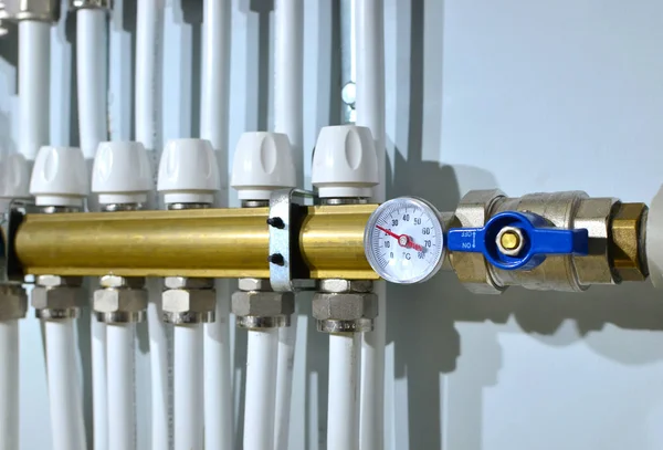 Close up of manometer, pipe, flow meter, water pumps and valves of heating system in a boiler room at home. Systems of water floor heating of  houses. Underfloor Heater Manifolds, background, texture