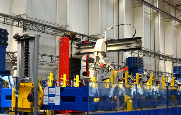 Robotic welding complex in the production workshop of an industrial plant. Complex production line, industrial robot in the automated filling factory. Arc welding background - Image