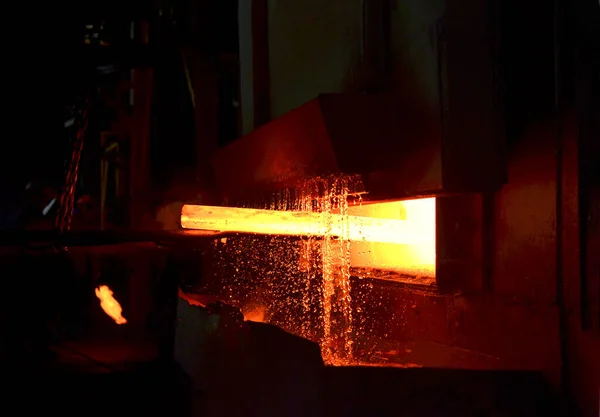 Steel quenching at high temperature in industrial furnace at the workshop of a forge plant. Process of cooling, heat treatmen. Blacksmith and metallurgical industry, steelmaking, hot rolling mill
