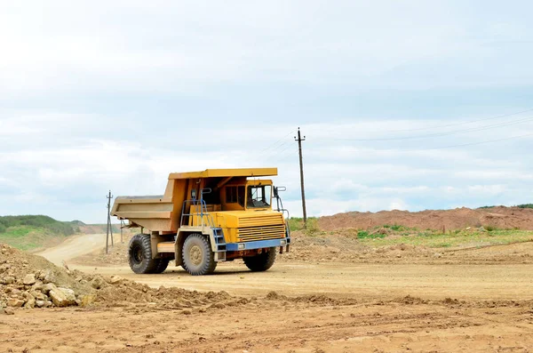 Big yellow mining truck working in the limestone open-pit. Loading and transportation of minerals in the dolomite mining quarry. Belarus, Vitebsk, in the largest dolomite deposit, quarry \