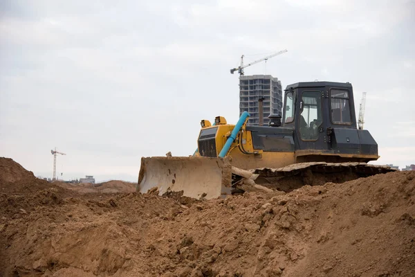 Bulldozer with bucket for pool excavation and utility trenching. Dozers during land clearing and foundation digging. Earth-moving equipment at construction site