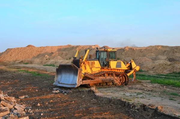 Bulldozer with bucket for pool excavation and utility trenching. Dozer during demolition concrete and asphalt at construction site. Earth-moving equipment for land clearing and foundation digging.