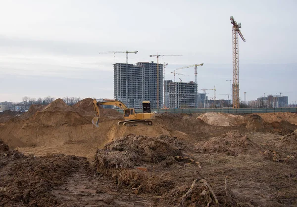 Excavator during groundwork on construction site. Hydraulic backhoe on earthworks. Heavy equipment for demolition, construction and ground works. Digging foundation and laying storm sewer pipes