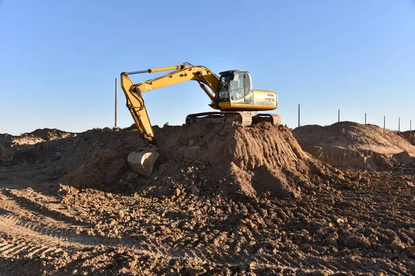 Digging the pit foundation a hole with excavator. Earthwork in excavation and backfilling of soil upto required depth is required for construction of trenche. Construction machinery for earthmoving