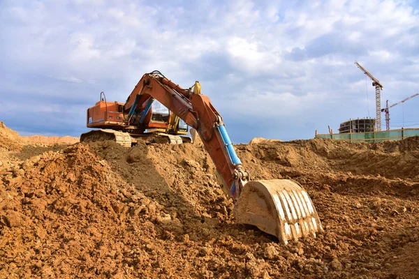 Digging the pit foundation a hole with excavator. Earthwork in excavation and backfilling of soil upto required depth is required for construction of trenche. Construction machinery for earthmoving