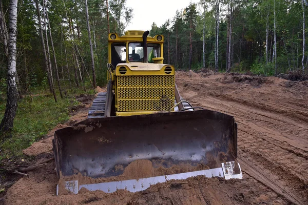 Dozer during clearing forest for construction new road . Yellow Bulldozer at forestry work Earth-moving equipment at road work, land clearing, grading, pool excavation, utility trenching