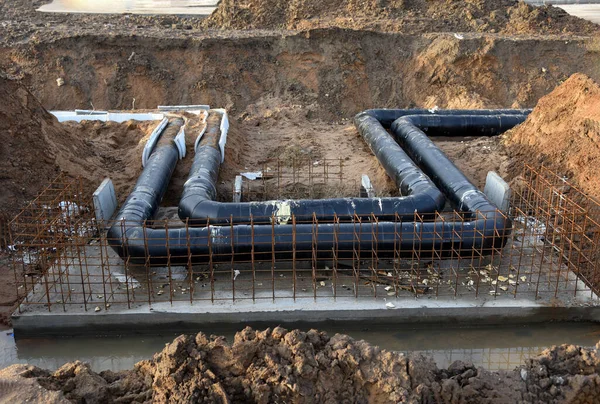 Laying of underground storm sewer pipes in ditch. Installation of water main and sanitary sewer at the construction site. Formwork solutions for reinforced construction and framed superstructure.