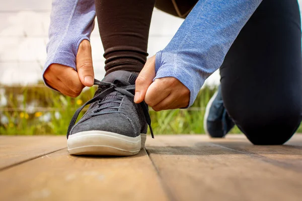 Un giovane uomo che si allacciava la scarpa prima di correre la mattina presto — Foto Stock