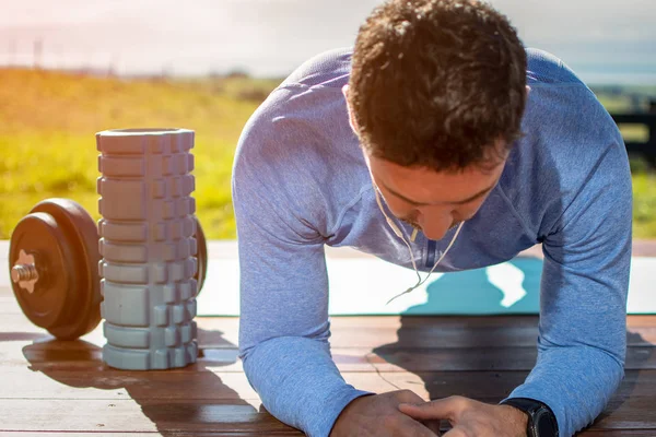 Güzel bir görünüme sahip bir güvertede yoga egzersizleri yapan genç bir adam