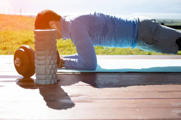 Güzel bir görünüme sahip bir güvertede yoga egzersizleri yapan genç bir adam