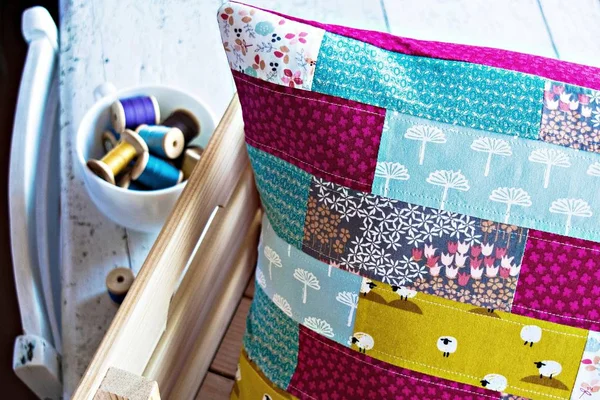 Handmade patchwork pillow case and vintage thread in the cup
