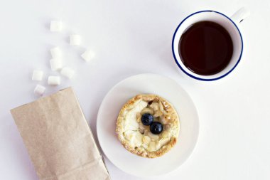  Yaban mersini, çay bardağı, şekerleme ve beyaz kraft kağıt torba ile pasta