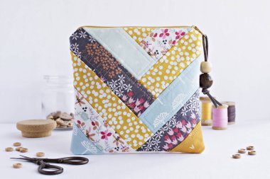 Kapitone patchwork kavramları çanta, düğmeler, retro makas ve vintage tahta makaralar üzerinde beyaz cam kavanoz