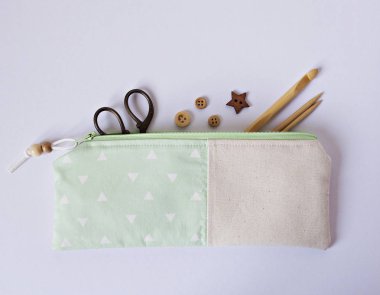 El yapımı naneli kumaş kavramı çanta, ahşap örgü iğneleri, düğmeler ve masaya makas