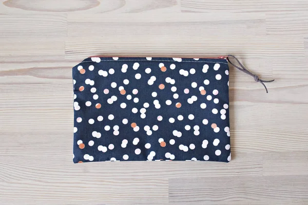 Polka dotted girl makeup bag on the wooden table