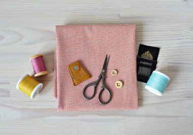 Kumaş, deri yüksük, retro makas, iğne ve masanın üzerine renkli konu kapitone ahşap düğme kontrol ettim