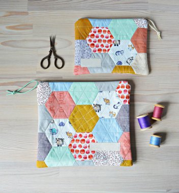 Renkli altıgen örülü keseler, retro makas ve ahşap masada iplik.