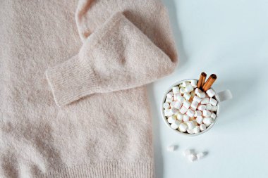 Beyaz üzerinde marshmallow ve tarçın ile açık pembe yün kazak ve fincan