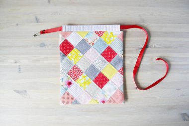 Renkli yama yaması çizgili çanta ve tahta masanın üzerinde emniyet pimi 