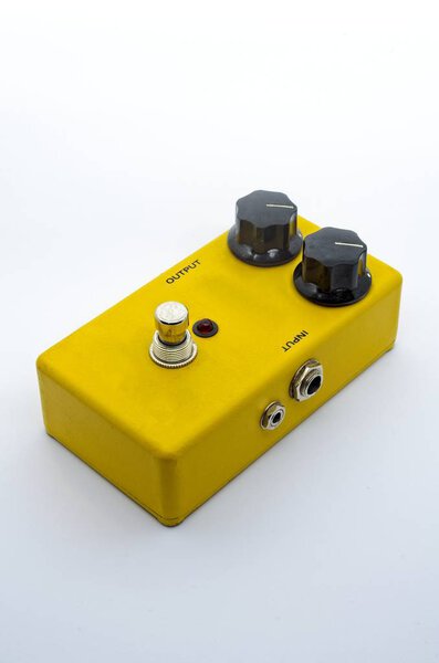 Yellow guitar effect pedal or stompbox on white background