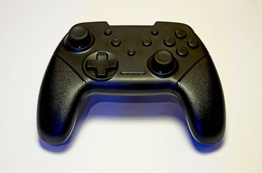 Beyaz arkaplanda siyah kablosuz oyun denetleyici