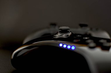 Siyah arkaplanda güçlü odaklanma kaybına sahip siyah kablosuz oyun denetleyicileri