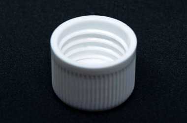 Siyah arka planda plastik beyaz başlık. Üretilmiş nesne