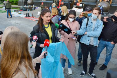 Eylemciler, Ukrayna Sağlık Bakanlığı 'nın Kiev' deki Ukrayna Cumhurbaşkanlığı Ofisi yakınlarındaki bir protesto sırasında şişirilmiş fiyatlarla satın aldığı Coronavirus COVID-19 salgını sırasında doktorlara koruyucu ekipman gösteriyorlar.