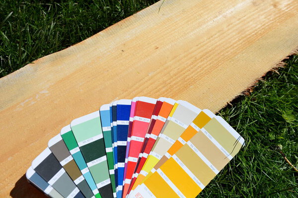 RAL color palette spread out on a wooden board on a background of green lawn