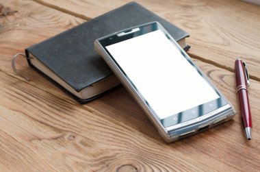 Kolu, telefon ve ahşap bir masa üstünde defter