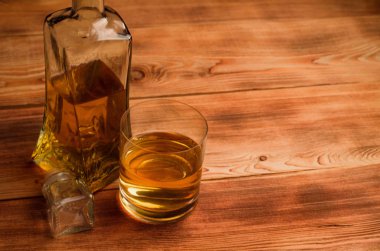 Ahşap bir masa viskiyle için gözlük