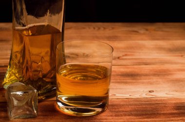 Ahşap bir masa viskiyle için gözlük