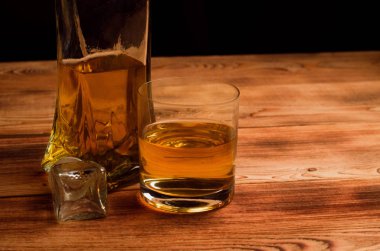 Ahşap bir masa viskiyle için gözlük