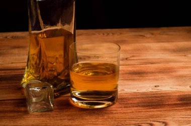 Ahşap bir masa viskiyle için gözlük