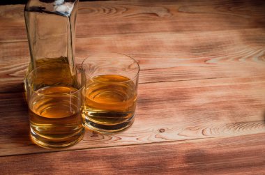 Ahşap bir masa viskiyle için gözlük