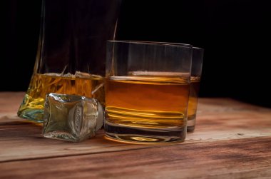 Ahşap bir masa viskiyle için gözlük