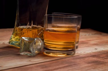 Ahşap bir masa viskiyle için gözlük