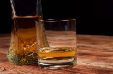 Ahşap bir masa viskiyle için gözlük