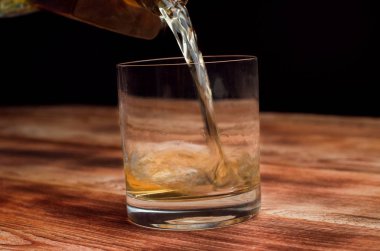 Ahşap bir masa viskiyle için gözlük