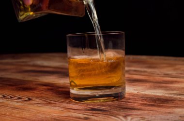 Ahşap bir masa viskiyle için gözlük