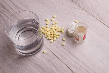 Tabletler ve bir bardak su tablo